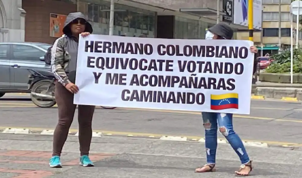 Migrantes venezolanos en las calles de Bogotá portan pancartas con advertencias para los ciudadanos colombianos que votarán el 19 de junio. Foto: NTN24