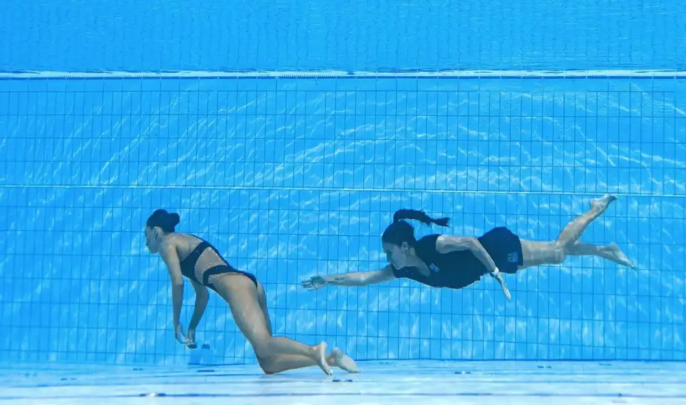 Andrea Fuentes fue al rescate por la nadadora estadounidense. Foto: AFP Andrea Fuentes fue al rescate por la nadadora estadounidense. Foto: AFP