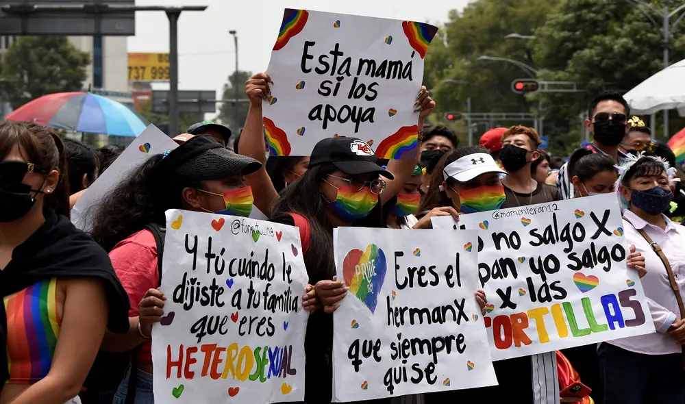 Las personas sostienen carteles que apoyan la diversidad de género durante el Desfile del Orgullo en la Ciudad de México el 25 de junio de 2022. Foto: AFP