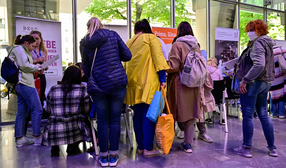 Migrantes hacen fila para obtener información en un stand en una feria de trabajo para extranjeros, en Berlín. Foto: AFP Migrantes hacen fila para obtener información en un stand en una feria de trabajo para extranjeros, en Berlín. Foto: AFP