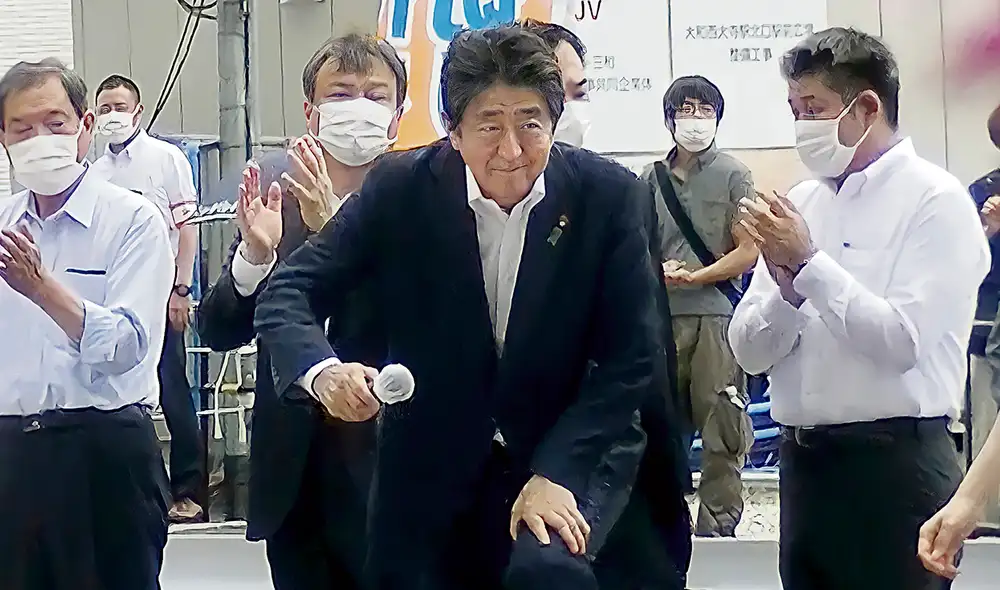 Sus últimas palabras. En esta imagen se ve al asesino instalado a pocos metros del político. Se puede ver la correa de la maleta en la que estaba el arma. Foto: difusión