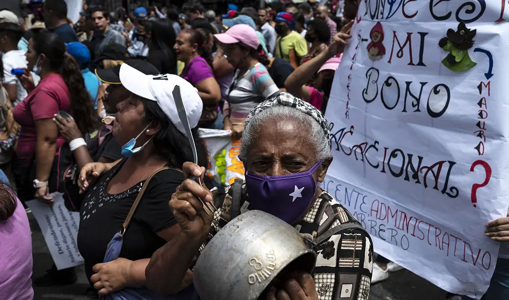 Enfermera jubilada golpea una olla con un tenedor durante una manifestación realizada por empleados jubilados de la salud y la educación exigiendo el pago de bonos y aumentos salariales. Foto: AFP Enfermera jubilada golpea una olla con un tenedor durante una manifestación realizada por empleados jubilados de la salud y la educación exigiendo el pago de bonos y aumentos salariales. Foto: AFP