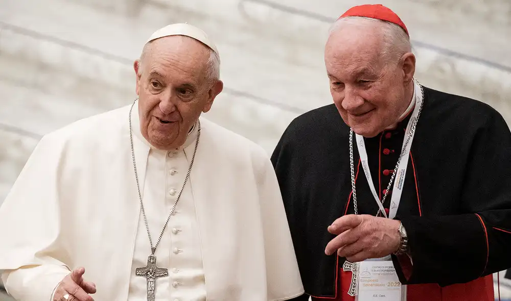 El papa Francisco y Marc Ouellet conversan, durante un simposio sobre el sacerdocio en el Vaticano. 17 de febrero de 2022. Foto: AFP