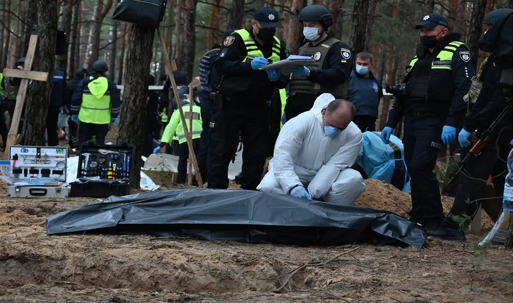 Un técnico forense cierra una bolsa para cadáveres en un bosque en las afueras de Izyum, en el este de Ucrania. Foto: AFP Un técnico forense cierra una bolsa para cadáveres en un bosque en las afueras de Izyum, en el este de Ucrania. Foto: AFP