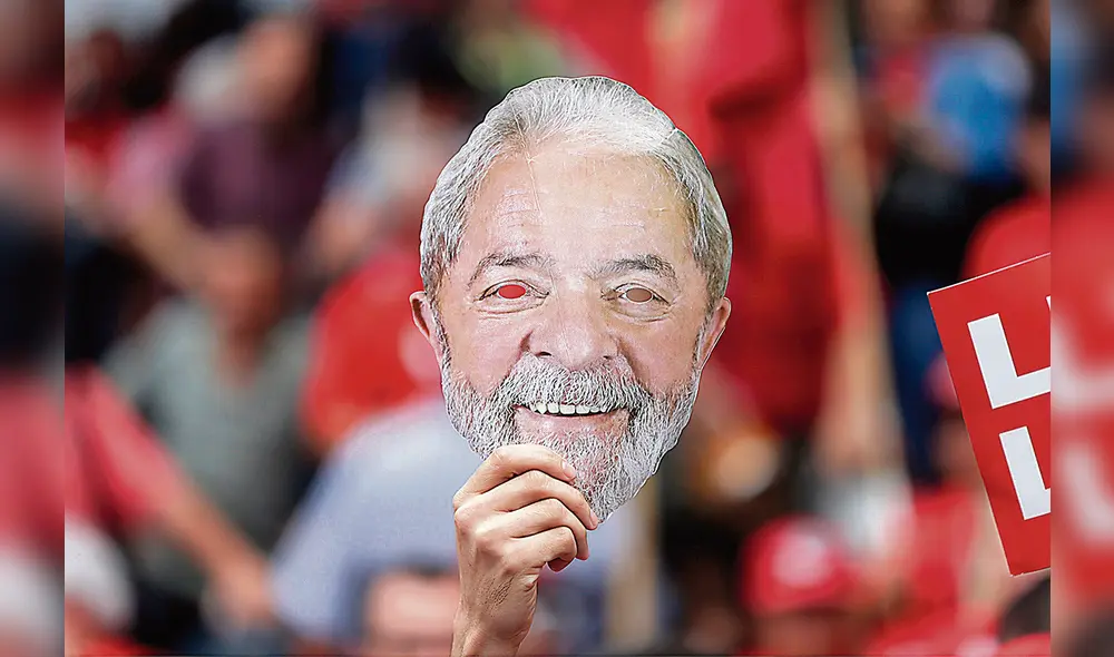 Caras y caretas. Un partidario de Lula da Silva muestra una máscara del exmandatario en el último día de la campaña. Foto: EFE