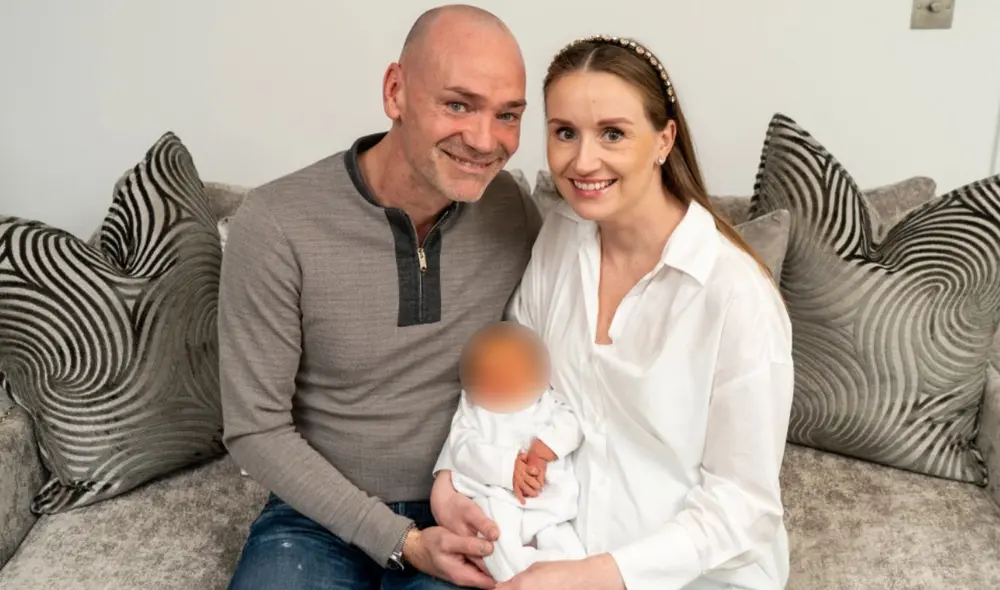 El bebé Kai es sostenido por sus padres Peter Hickles (47 años) y Aurelija Aperaviciute (32 años). Foto: Louis Wood