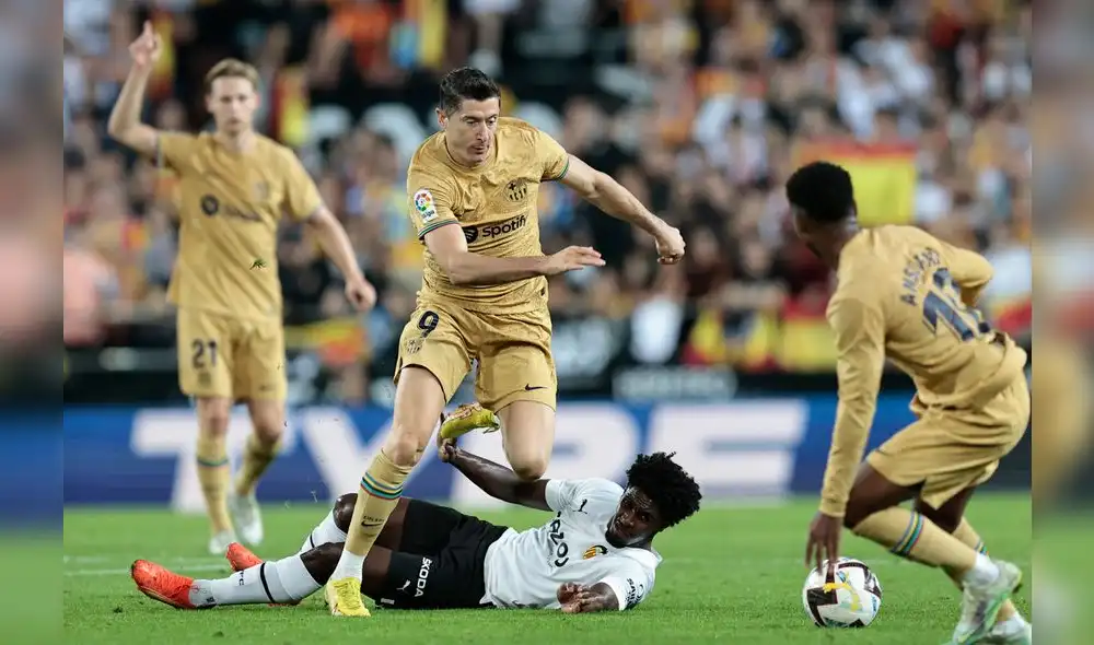 Robert Lewandowski supera al jugador del rival durante el partido entre Valencia CF y FC Barcelona. Foto: EFE