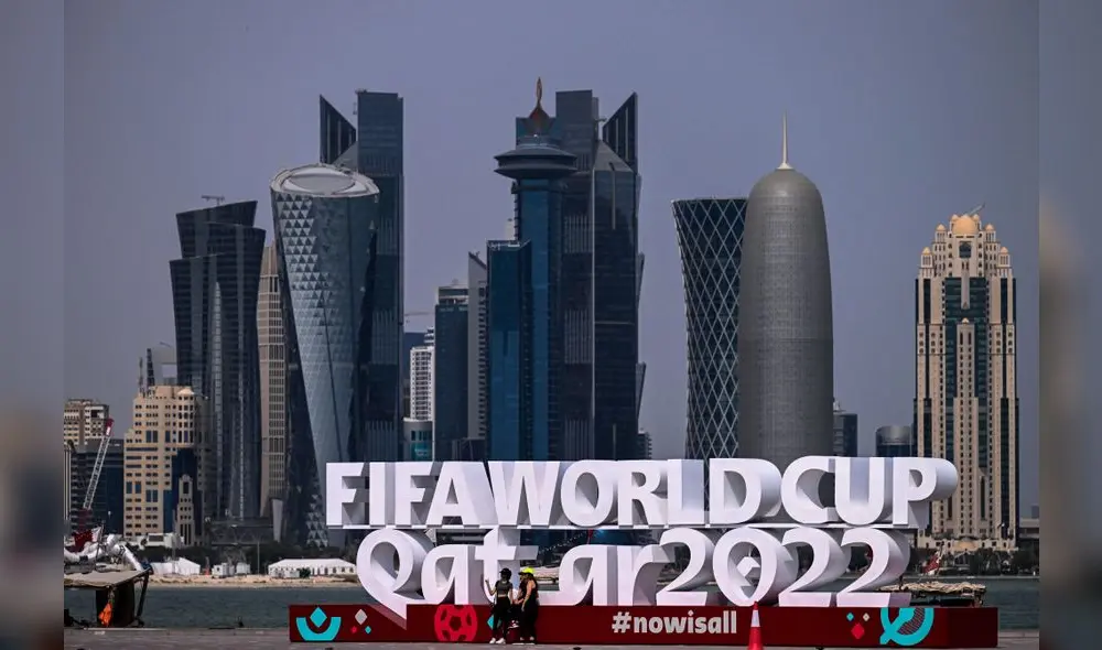 La gente visita la cornisa adornada con un cartel de la FIFA en Doha, capital de Qatar y la Copa Mundial de la FIFA 2022. Foto de Joya SAMAD / AFP