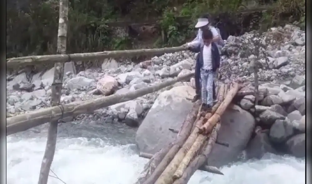 Niños cruzan puente de palos para llegar a sus escuelas. Foto: Captura de pantalla Alba López Niños cruzan puente de palos para llegar a sus escuelas. Foto: Captura de pantalla Alba López