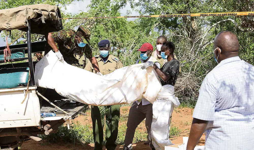 Más cadáveres . Agentes de la policía trasladan otro cadáver hallado en la zona convertida en una enorme fosa común. Foto: EFE