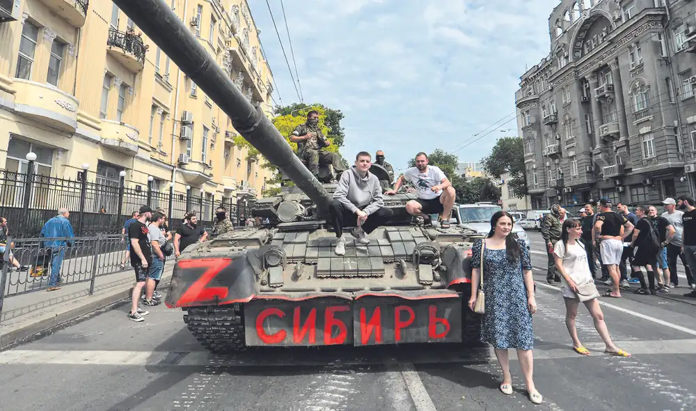 Repliegue. Pobladores de Rostov-on-Don, al sur de Moscú, posan cerca de un blindado de la compañía militar privada Wagner. Foto: EFE