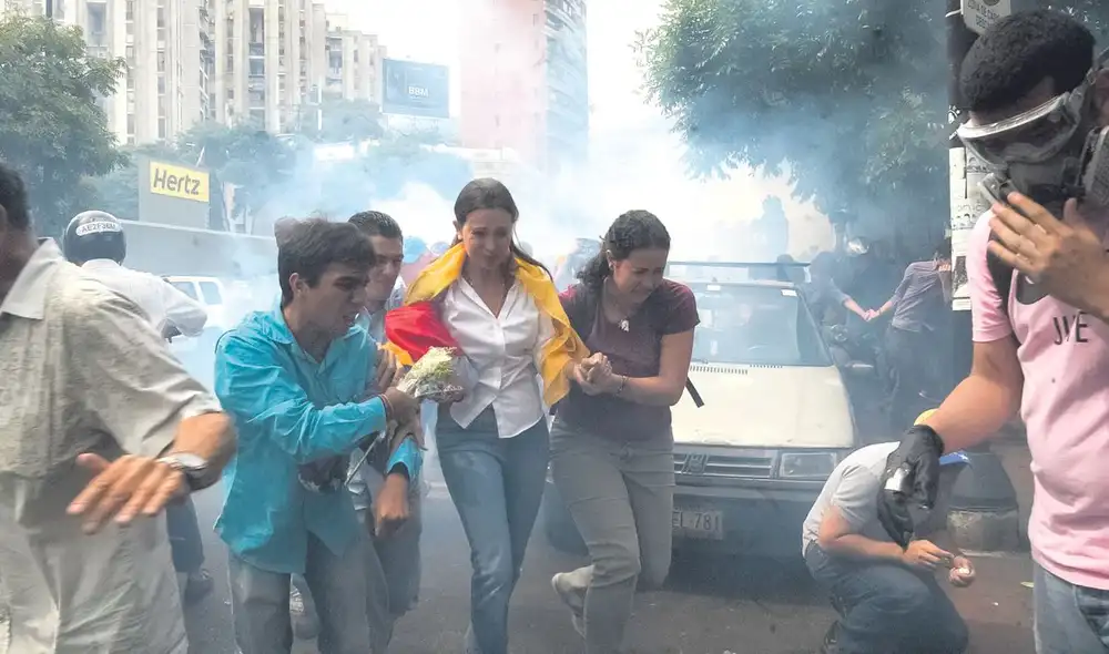 Campaña violenta. La candidata opositora escapa de los gases lacrimógenos en una reciente manifestación en Caracas. Foto: Difusión