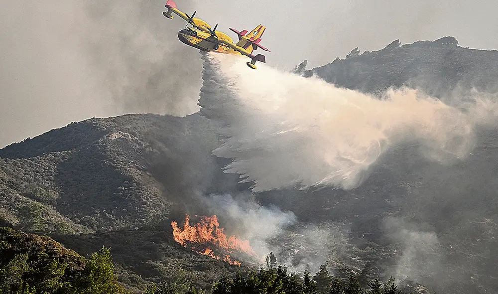 Insuficiente. Un hidroavión esparce toneladas de agua sobre un incendio forestal en Rodas. Foto: difusión Insuficiente. Un hidroavión esparce toneladas de agua sobre un incendio forestal en Rodas. Foto: difusión