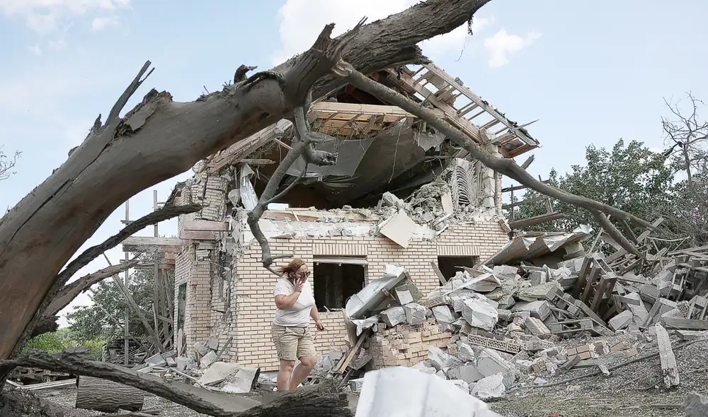 Destrucción. Una residente civil en las cercanías de Kiev, delante de los escombros de su casa tras un ataque ruso. Foto: EFE