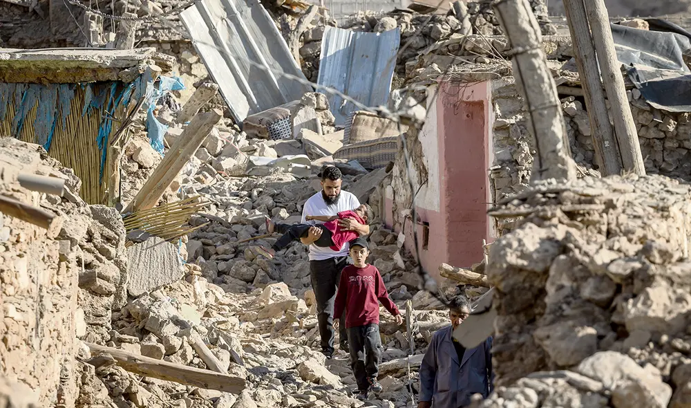Rescate. Familiares se ocupan personalmente de socorrer a los menores que han quedado atrapados entre los escombros de las viviendas. Foto: AFP