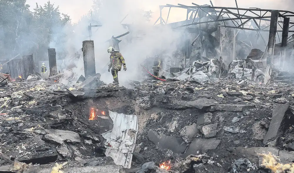 Impacto profundo. Un rescatista camina por el enorme cráter que dejó el impacto de un misil ruso en un barrio de Kiev. Foto: EFE