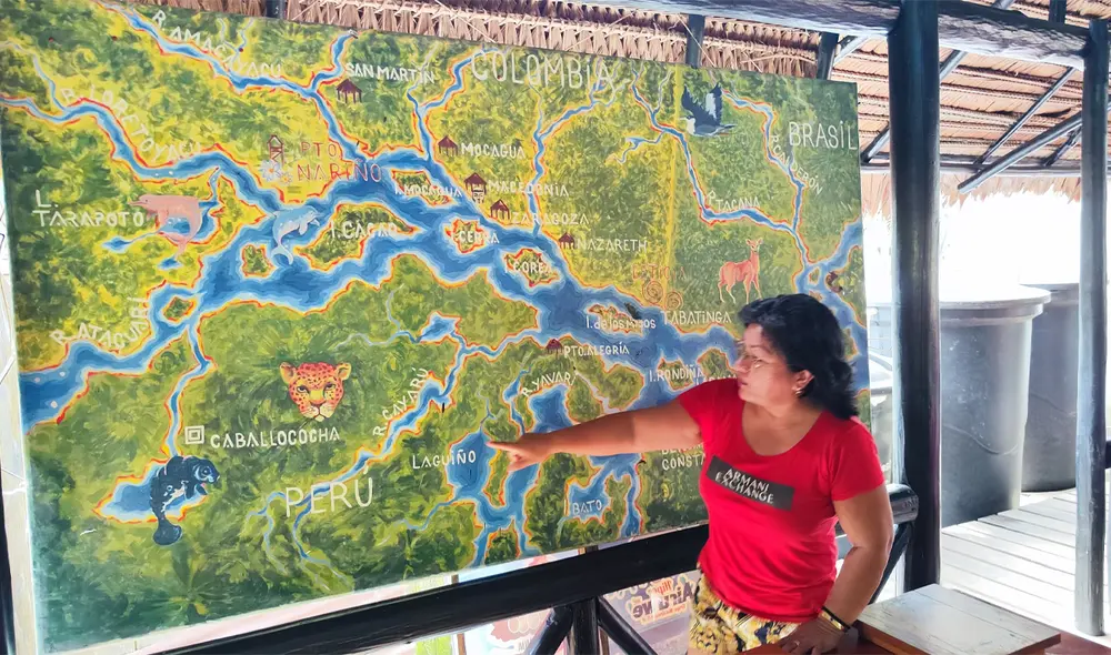 Mary Celis, del hotel El Cauchero de Iquitos, ante el mapa del descomunal río Amazonas en la frontera tripartita. Foto: Marco Zileri/La República