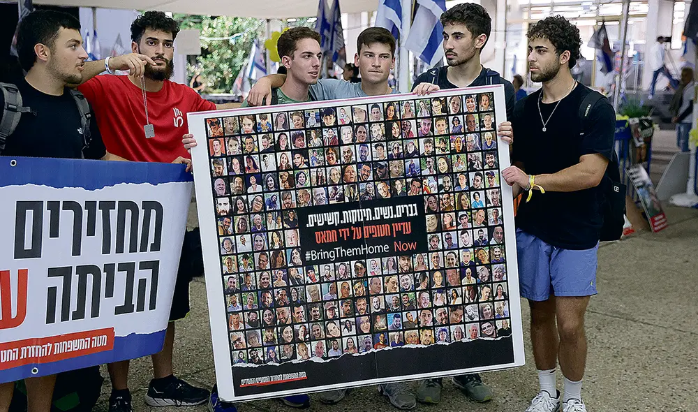 Secuestrados. Jóvenes sostienen una pancarta que muestra fotografías de personas secuestradas por militantes de Hamás. Foto: EFE Secuestrados. Jóvenes sostienen una pancarta que muestra fotografías de personas secuestradas por militantes de Hamás. Foto: EFE