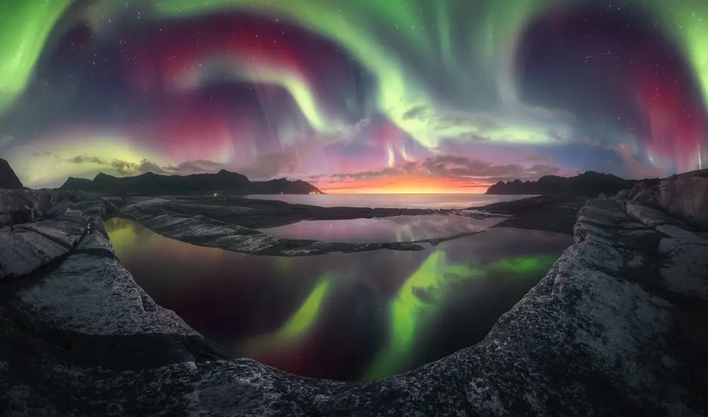 Auroras boreales capturadas en la isla de Senja, Noruega, donde también se ve el Sol poniéndose. Foto: Alex Wides/Capture the Atlas