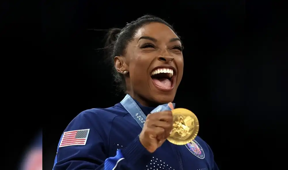 Simone Biles feliz mostrando su nueva presea dorada, la primera conseguida en París 2024
