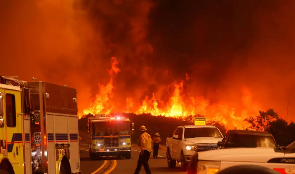 Los bomberos combaten un incendio forestal en el noroeste de Los Ángeles, evacuando a más de 14.000 personas en California por condiciones climáticas extremas que agravan la situación. Foto: composición LR/AFP. Los bomberos combaten un incendio forestal en el noroeste de Los Ángeles, evacuando a más de 14.000 personas en California por condiciones climáticas extremas que agravan la situación. Foto: composición LR/AFP.
