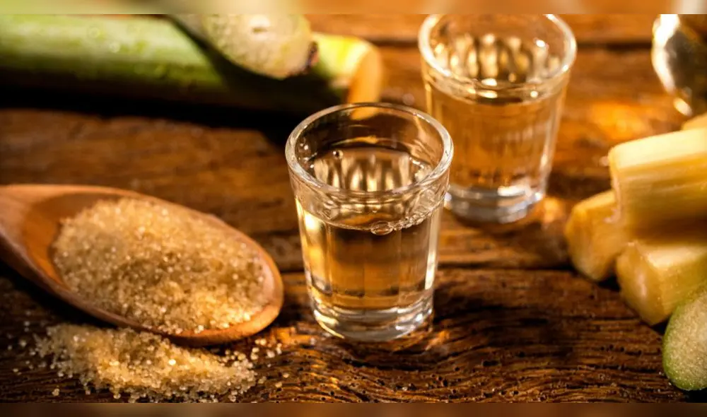 Vasos llenos de bebida cañazo junto a cañas de azúcar. Foto: Buenazo