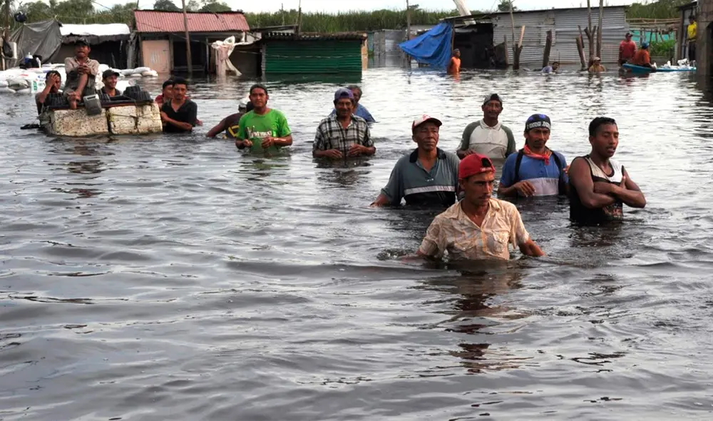 Pobladores obligados a caminar sobre las aguas. Foto: Andina