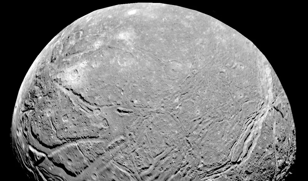 El Voyager reveló la superficie densamente picada y agrietada de la luna Ariel de Urano que llevaría hacia un océano bajo la superficie de Urano, según estudio. Foto: NASA.