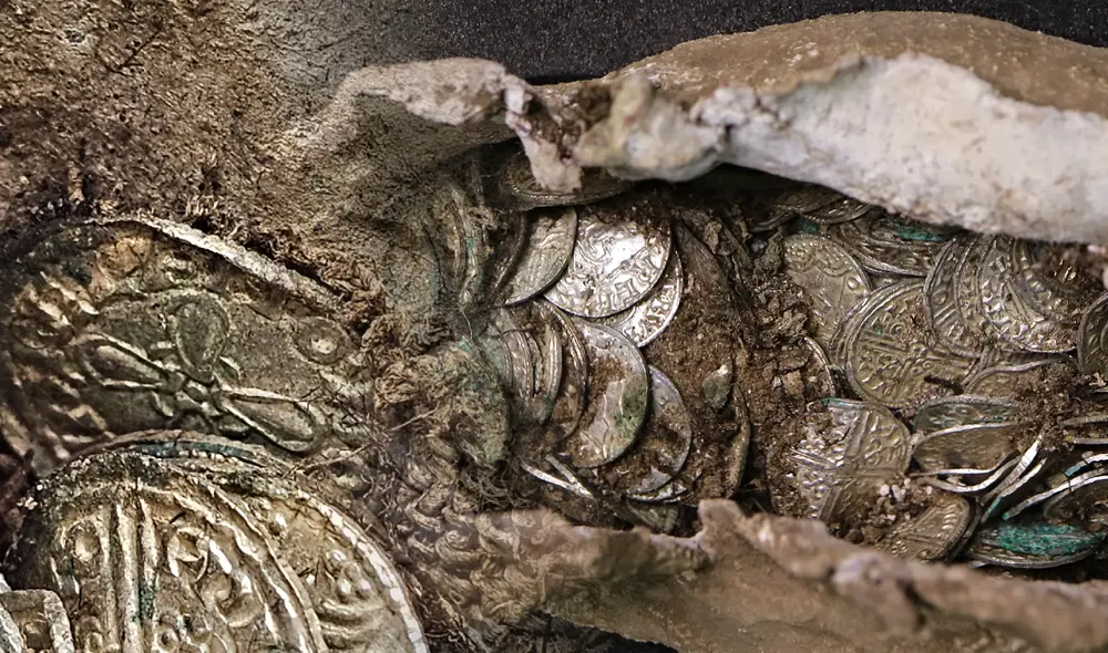 Andrew Pegg, el arqueólogo responsable del hallazgo, encontró el tesoro de monedas cuidadosamente envuelto. Foto: composición LR/Oxford Cotswold Archaeology.