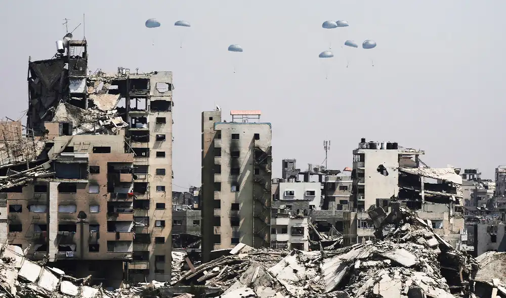 Ayuda humanitaria lanzada desde el aire cae sobre las ruinas de Gaza, este lunes en la capital del enclave. Foto: El país