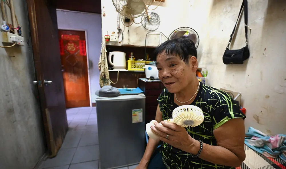 Mujer de Hong Kong en su departamento de 4.6 metros cuadrados. Mujer de Hong Kong en su departamento de 4.6 metros cuadrados.