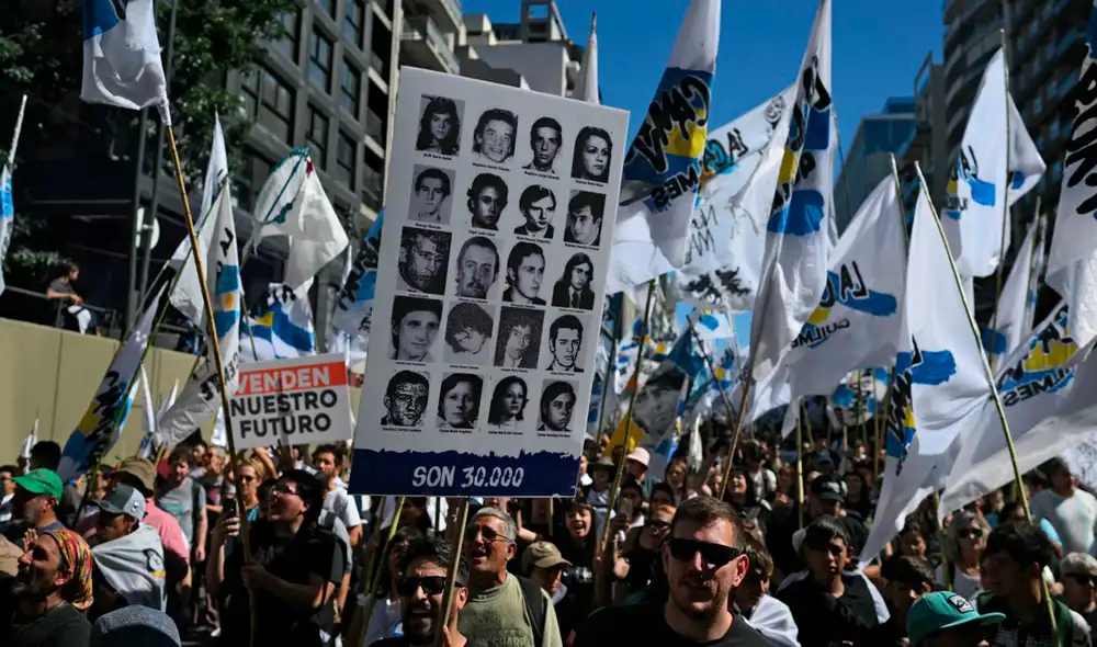 Manifestantes portan fotografías de personas desaparecidas durante una marcha hacia la Plaza de Mayo en Buenos Aires.