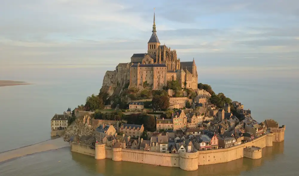 Mont Saint-Michel, en Normandía, Francia, es famoso por sus dramáticos cambios de paisaje causados por las mareas, que transforman su acceso y vista en cada visita.