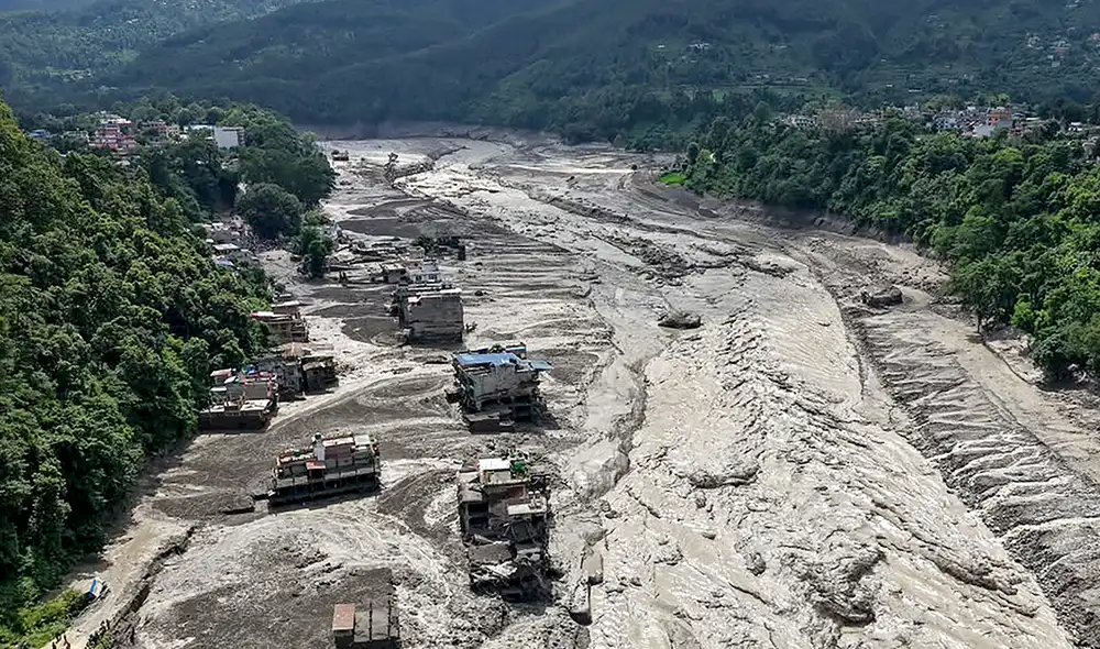 Varias casas quedaron sumergidas en lodo lo largo de la ribera de un río tras las inundaciones repentinas en Nepal. Foto: AFP