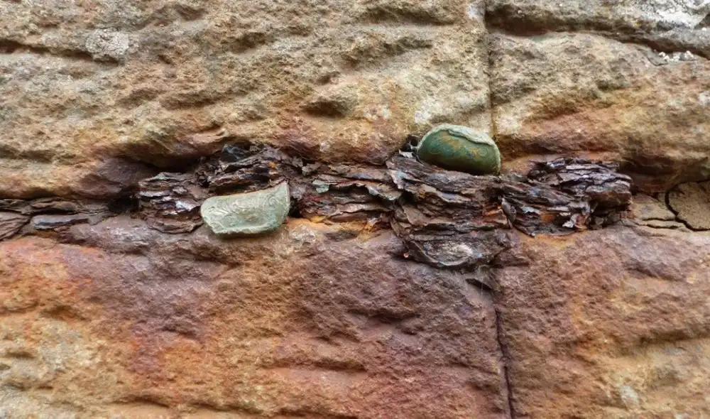 Los visitantes golpeaban las monedas con otras piedras para introducirlas en las grietas. Foto: National Trust
