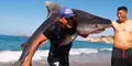 Hombre sale del mar cargando un enorme tiburón sobre sus hombros y en redes le dicen "El verdadero Aquaman"