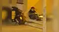Joven repartidor estudia bajo la luz de poste mientras espera un pedido