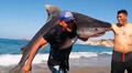Hombre sale del mar cargando un enorme tiburón sobre sus hombros y en redes le dicen "El verdadero Aquaman"
