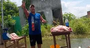 ¡Emprendedor con mente de tiburón! Recorre zona inundada de Ecuador en bote para vender carne de cerdo