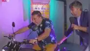 Carlos Carlín se emociona al ganar una moto, pero casi sufre accidente al intentar manejarla