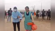 Mujeres llevan desayuno a extranjeros que permanecen en la frontera de Perú y Chile
