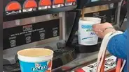 Mujer aprovecha café gratis durante inauguración de tienda y se lleva 2 litros en grandes vasos
