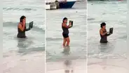 Captan a mujer dentro del mar con su laptop y usuarios bromean: “De vacaciones, pero responsable"