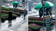 Trabajadores salen a almorzar y llevan enorme sombrilla para evitar mojarse ante intensa lluvia