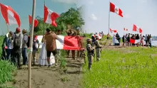 Ciudadanos de Santa Rosa izan bandera de Perú, mientras cantan himno nacional