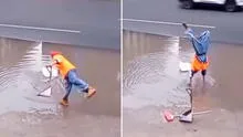 Trabajador de limpieza se para de manos para recoger una bolsa y evitar mojarse los zapatos en inundación
