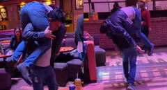 Joven ayuda a su amigo en estado de ebriedad y lo carga en su espalda para llevarlo a casa