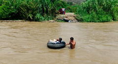 Niños y adultos mayores cruzan río sobre cámaras de llanta ante colapso de puente artesanal