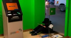 Niño en Huancayo realiza su tarea dentro de cajero automático, mientras su madre trabaja como vendedora en la calle