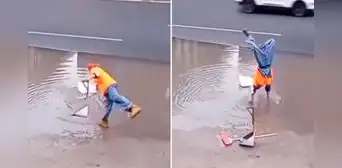 Trabajador de limpieza se para de manos para recoger una bolsa y evitar mojarse los zapatos en inundación